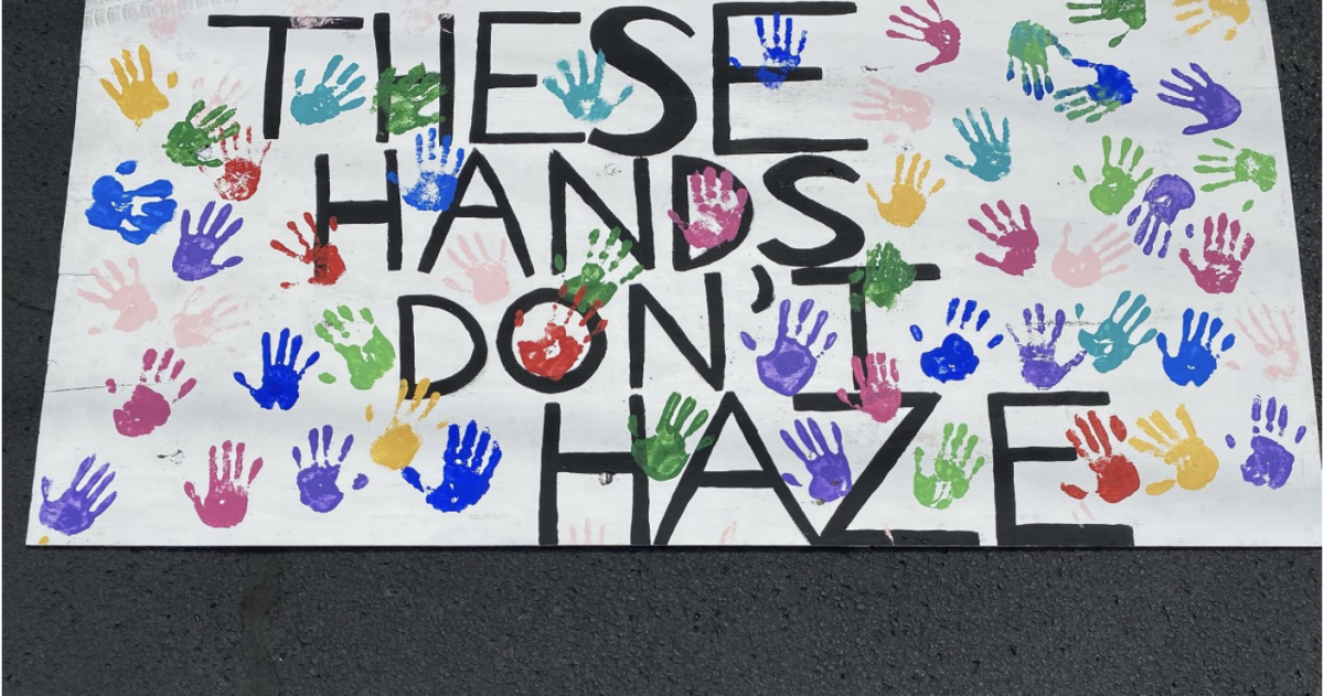 A large poster created during National Haze Prevention Week reading "These Hands Don't Haze," covered in handprints.Photo courtesy of The Parthenon